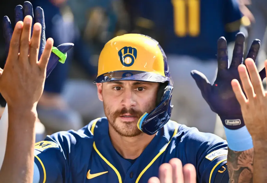 Joey Ortiz of the Milwaukee Brewers high fives teammates after...