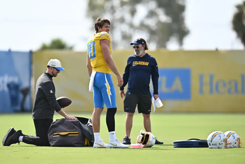 Chargers quarterback Justin Herbert, center, looks on during a training...