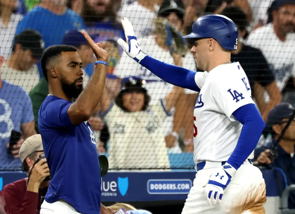 The Dodgers’ Freddie Freeman, right, celebrates his go-ahead RBI single...