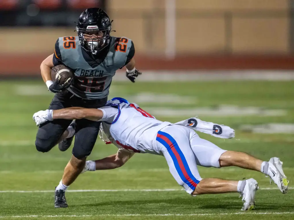 Huntington Beach running back Nathan Santillian (25) breaks a tackle...