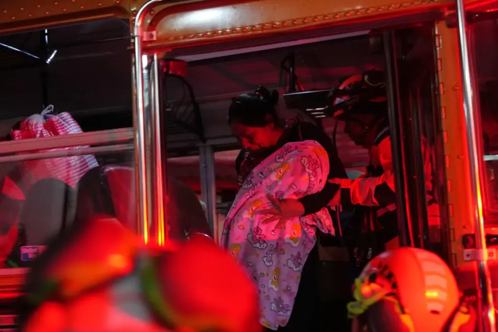Families evacuated from areas surrounding the Fuego Volcano arrive to...