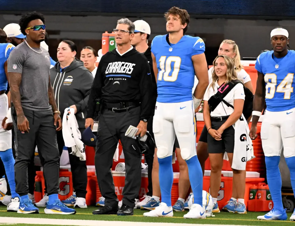 Chargers quarterback Justin Herbert (10) stands next to head coach...