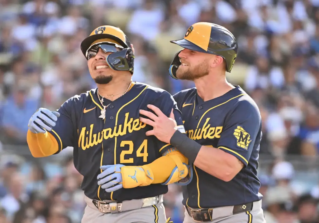 William Contreras of the Milwaukee Brewers reacts with teammate Jake...