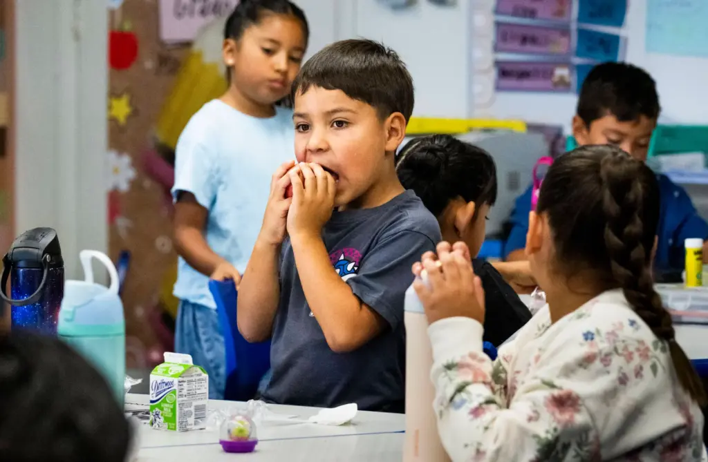 Second-grade student Obed Cruz eats an apple during breakfast at...