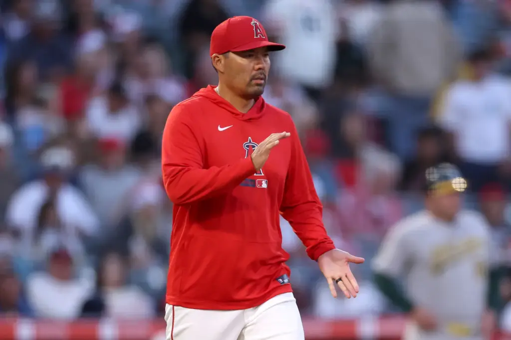 Angels manager Kurt Suzuki walks to the mound to change...