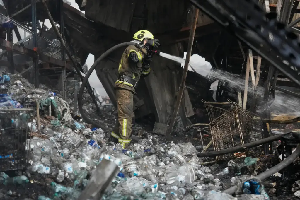 A firefighter puts out a fire after Russian missiles hit a food warehouse near Kyiv, Ukraine.