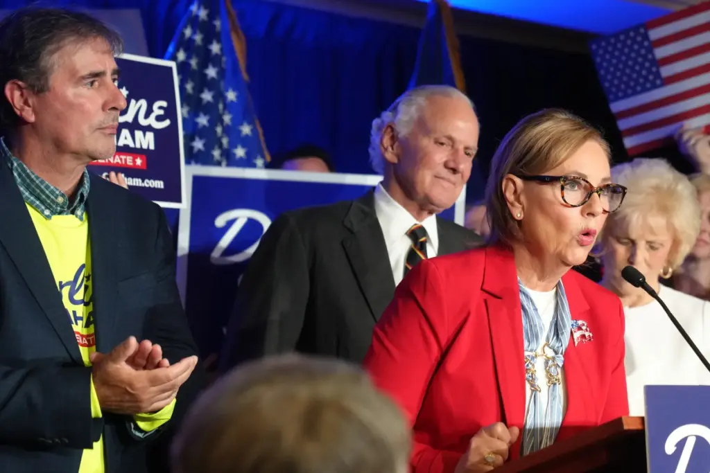 Larry Nordone and Gov. Henry McMaster, R-S.C., look on as Sen. Darline Graham speaks.