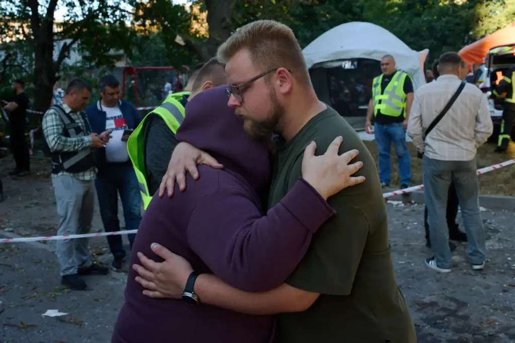 Relatives of a person killed during an overnight Russian attack comfort each other.