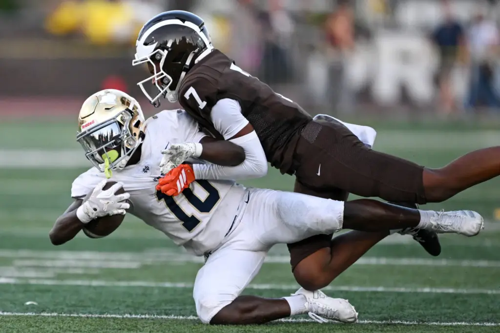 Notre Dame’s Nolen Washington (10) is brought down by Crespiâs...