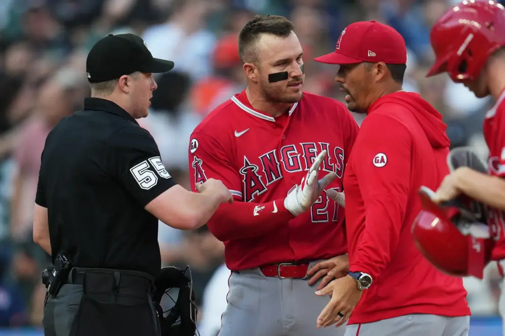 Angels manager Kurt Suzuki, right, is held back by star...
