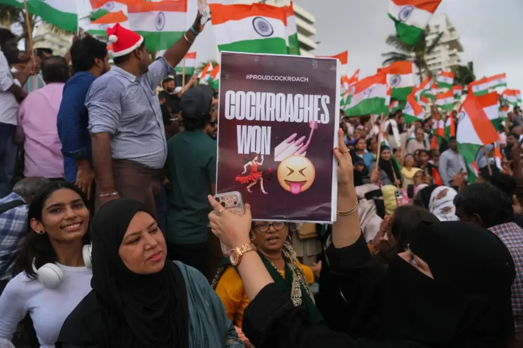 A protester holds a placard after India's Education Minister Dharmendra Pradhan resigned.