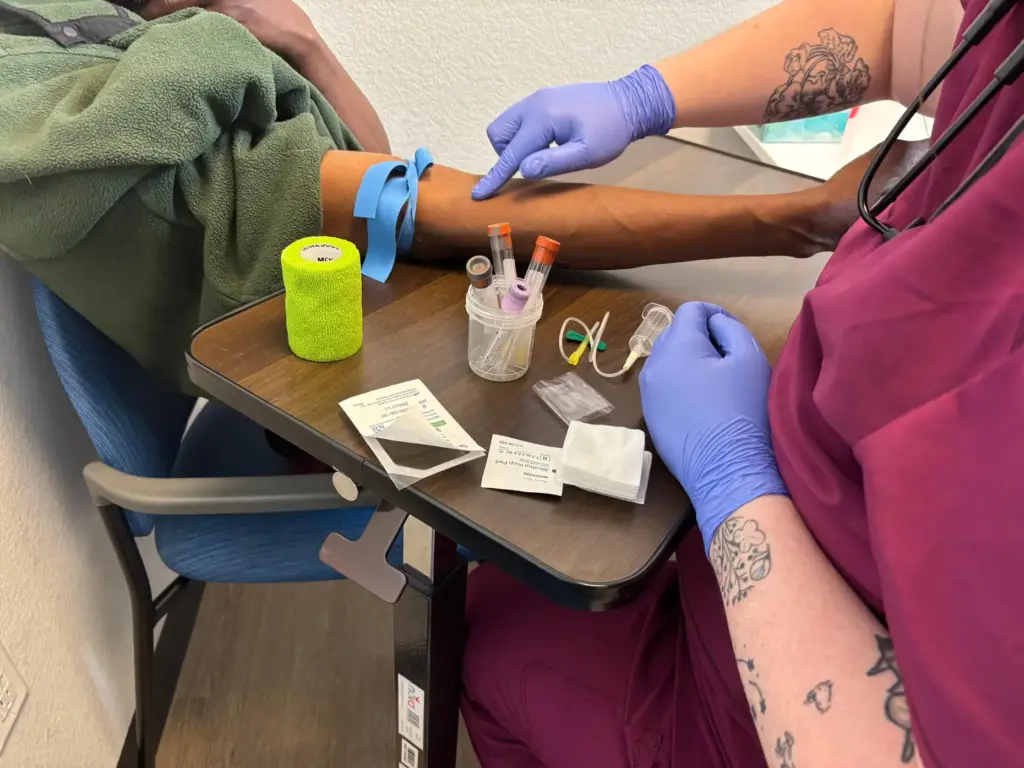 Izzy Kadrmas prepares to take Tywon Pugh's blood.