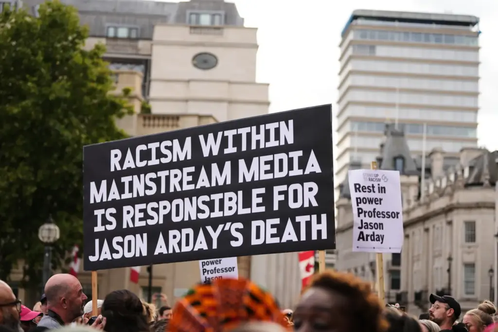People hold signs during a vigil held by Stand Up...