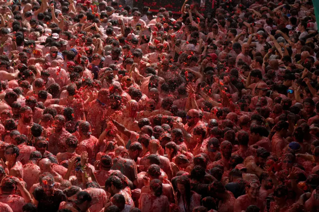 Revelers throw tomatoes at each other during the annual “Tomatina”...