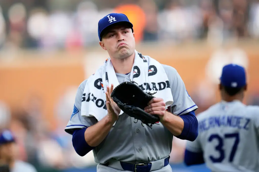 Dodgers starting pitcher Tarik Skubal claps as he walks to...