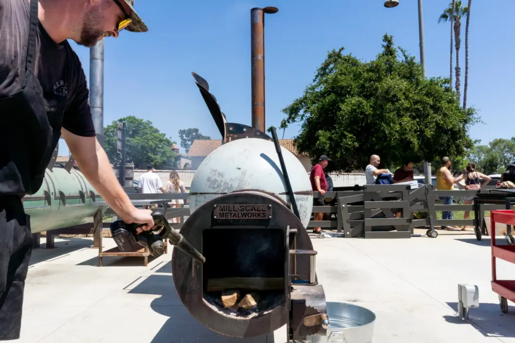 Daniel Payne allows air into the firebox of a smoker...