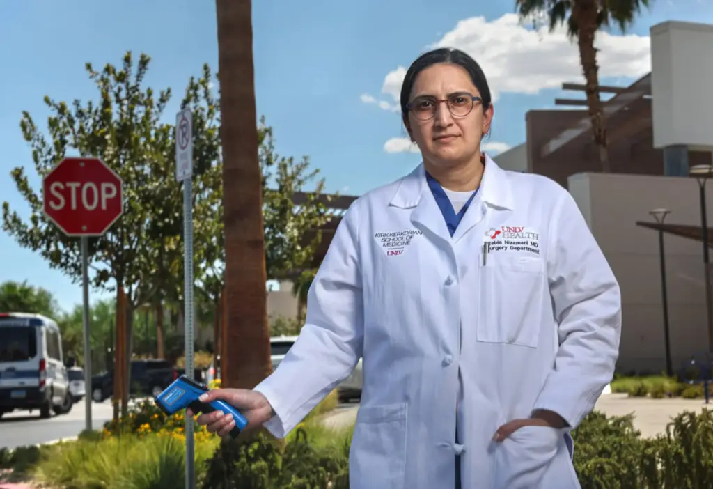 Rabia Nizamani holds an infrared thermometer.