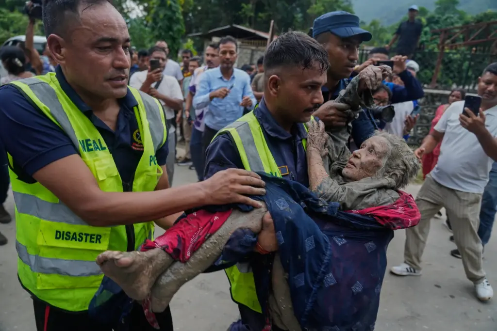 Rescuers carry a victim of flash flooding to safety along the Trishuli River.