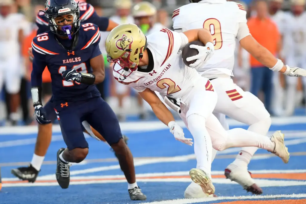 Oaks Christianâs Xavier Burkett (2) fights to stay on his...