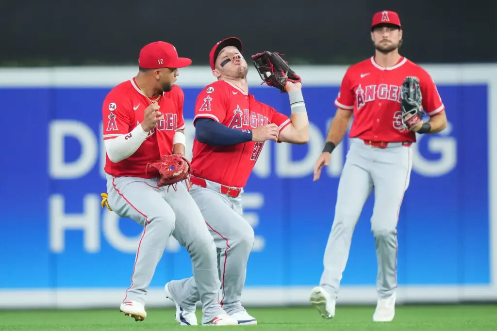 Angels center fielder Mike Trout, middle, catches a fly ball...