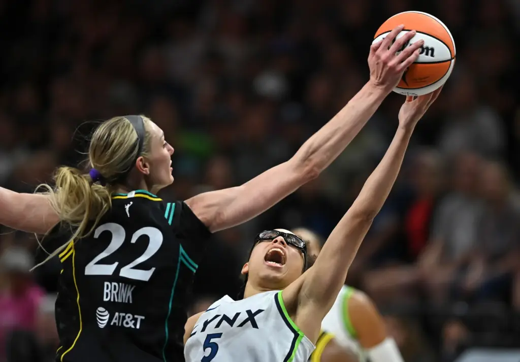 Sparks forward Cameron Brink, left, blocks a shot by Minnesota...