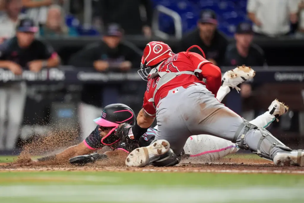 The Miami Marlins’ Leo Jimenez is tagged out at home...