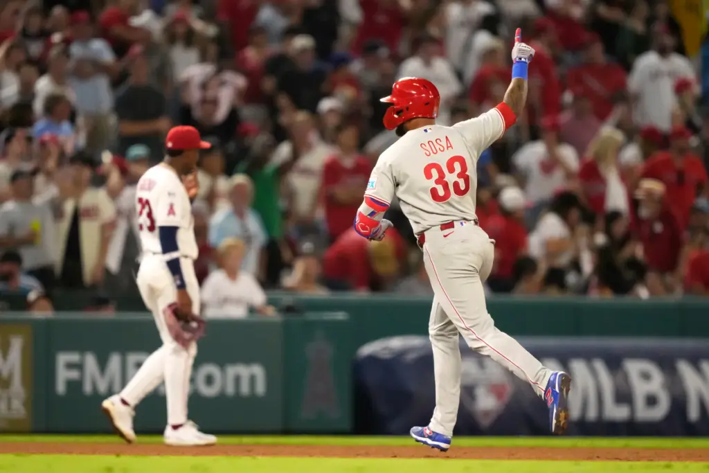 The Philadelphia Phillies’ Edmundo Sosa, right, gestures as he runs...
