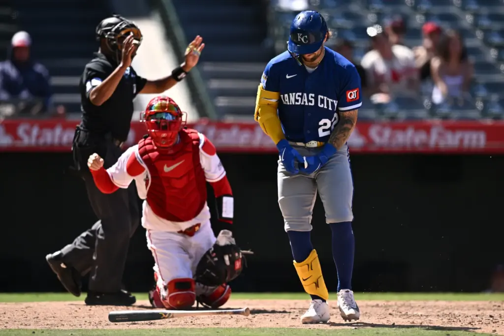 Kansas City Royals’ Carter Jensen, right, reacts after being hit...