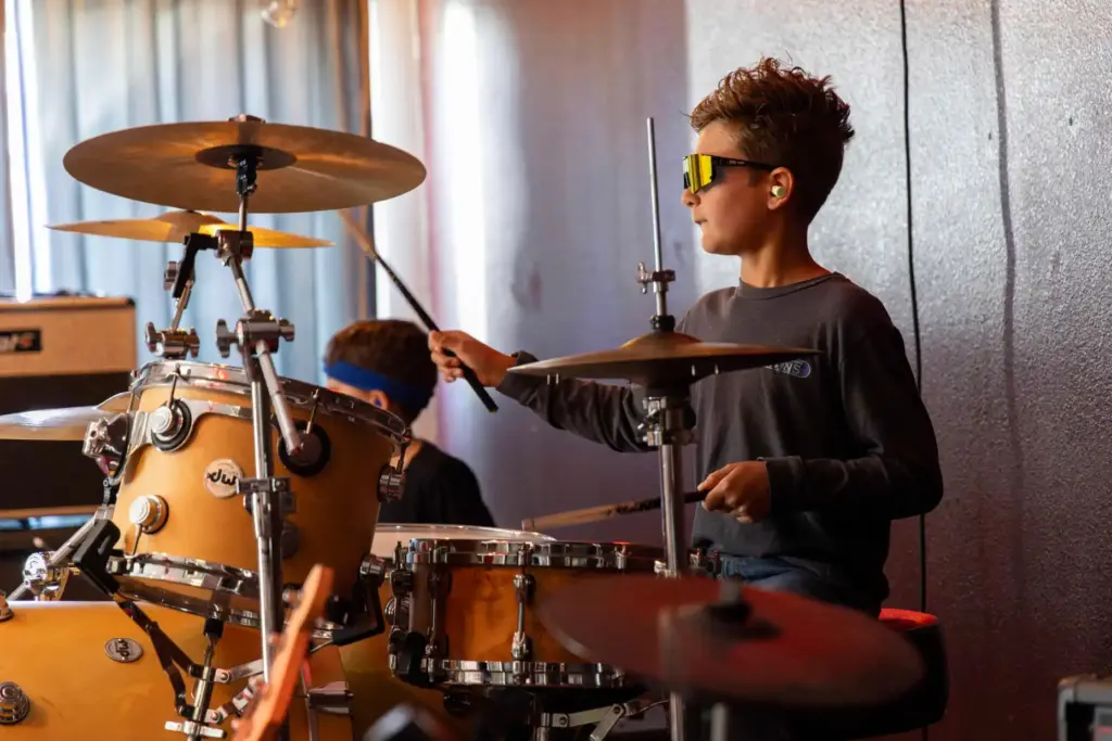 Jace Nelson, 10, plays the drums while rehearsing before his...