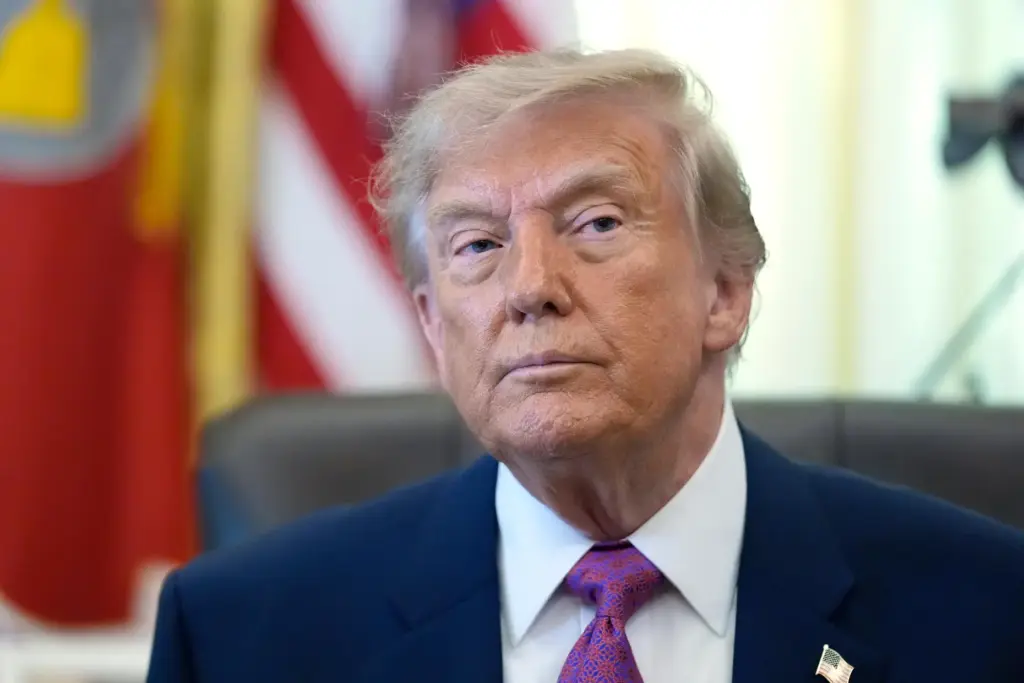 President Donald Trump listens as a reporter asks a question...