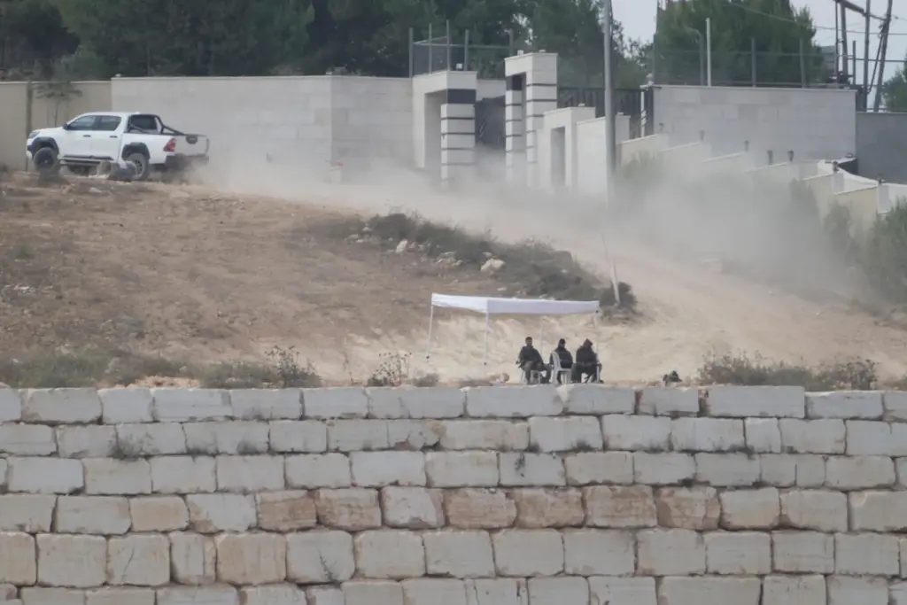 Israeli soldiers sit under a tent in front of Loui Ridi's house.