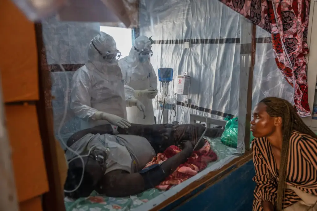 Health workers tend to an Ebola patient at the Rwampara Treatment Center.