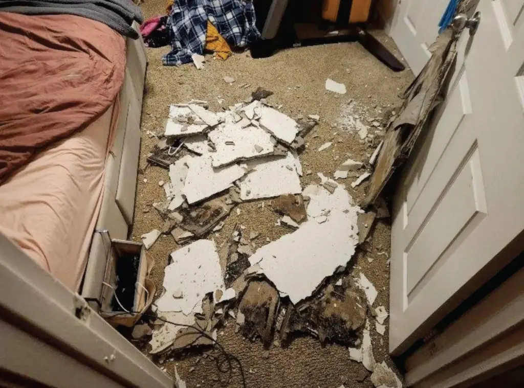 Drywall from a caved-in ceiling lays on the floor in the primary bedroom.