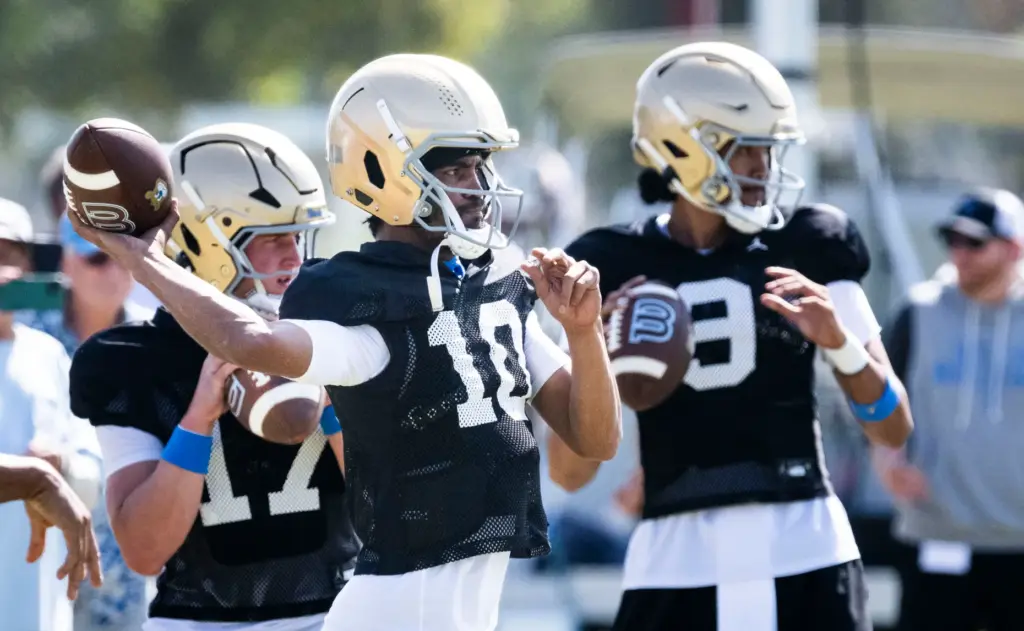 UCLA quarterback Madden Iamaleava, left, goes through drills alongside his...