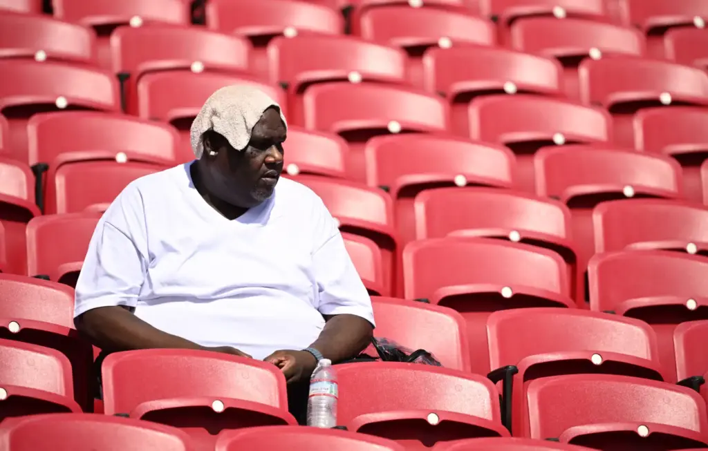 A football fan tries to stay cool prior to a...