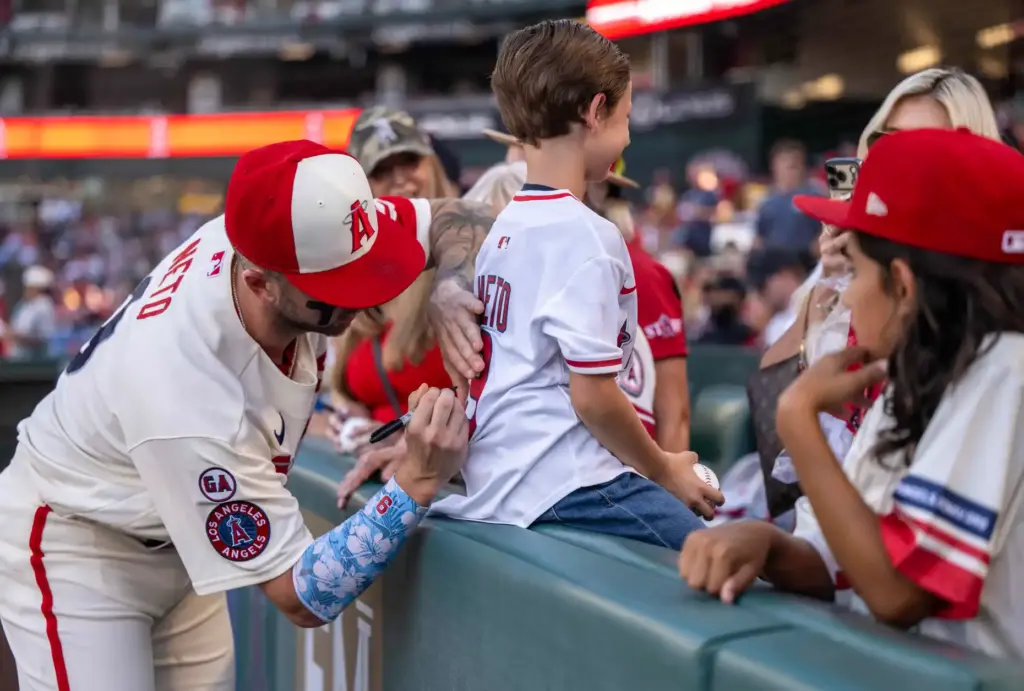 Angels shortstop Zach Neto (9) signs a jersey for young...
