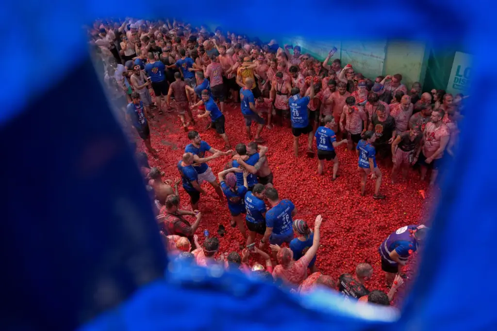Revelers throw tomatoes at each other during the annual “Tomatina”...