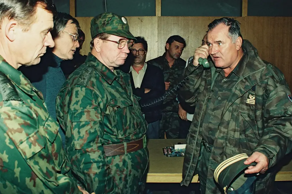 FILE – Bosnian Serb General Ratko Mladic, right, talks on...