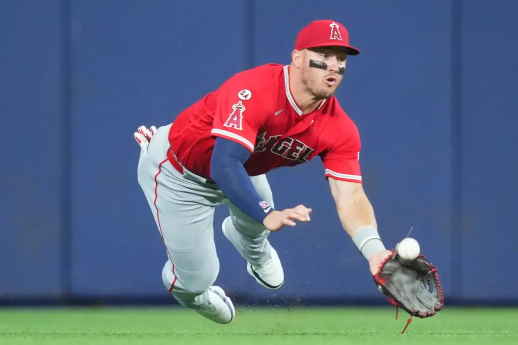 Angels center fielder Mike Trout dives as he tries to...