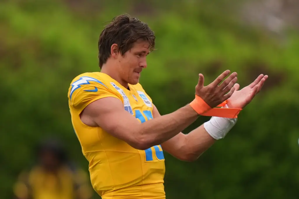 Chargers quarterback Justin Herbert stretches during an NFL football training...