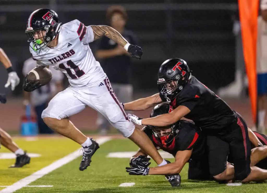 Tustin running back Steele Holcomb (11) breaks tackles while carrying...