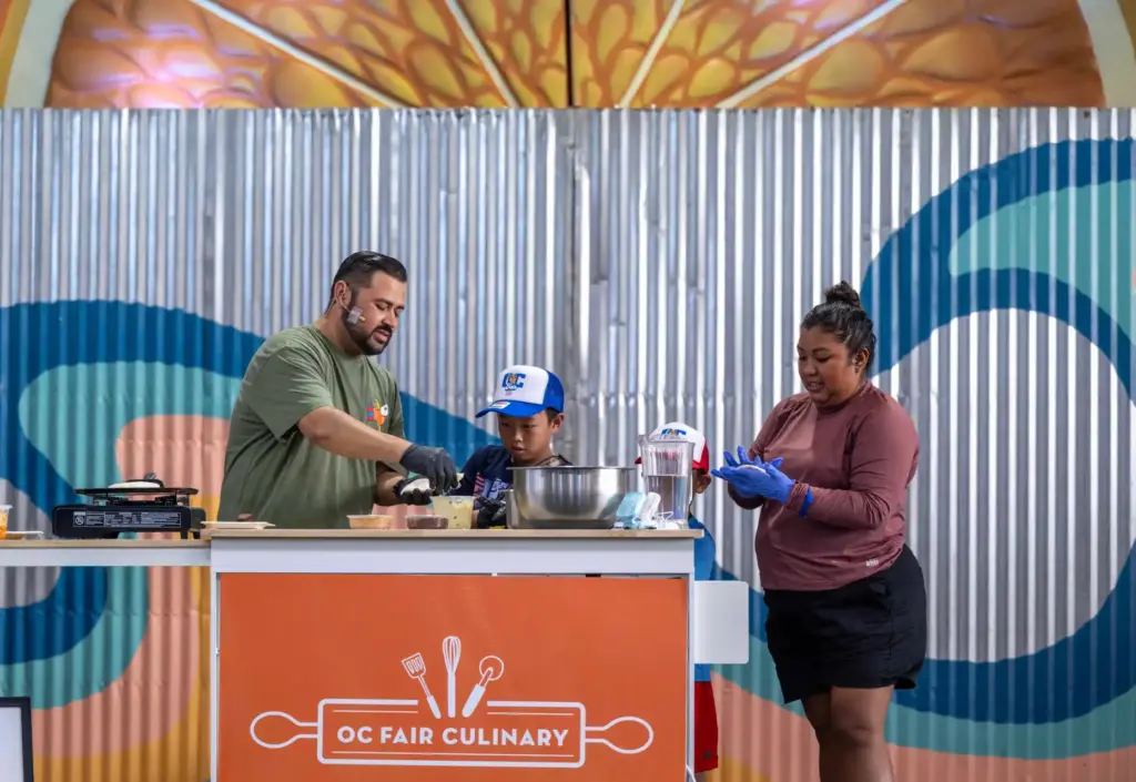 Chef Eder uses help from audience volunteers during a pupusa-making...