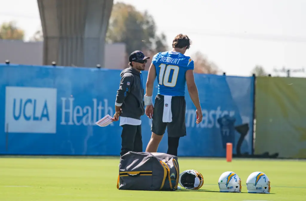 Los Angeles Chargers offensive coordinator Mike McDaniel chats with quarterback...