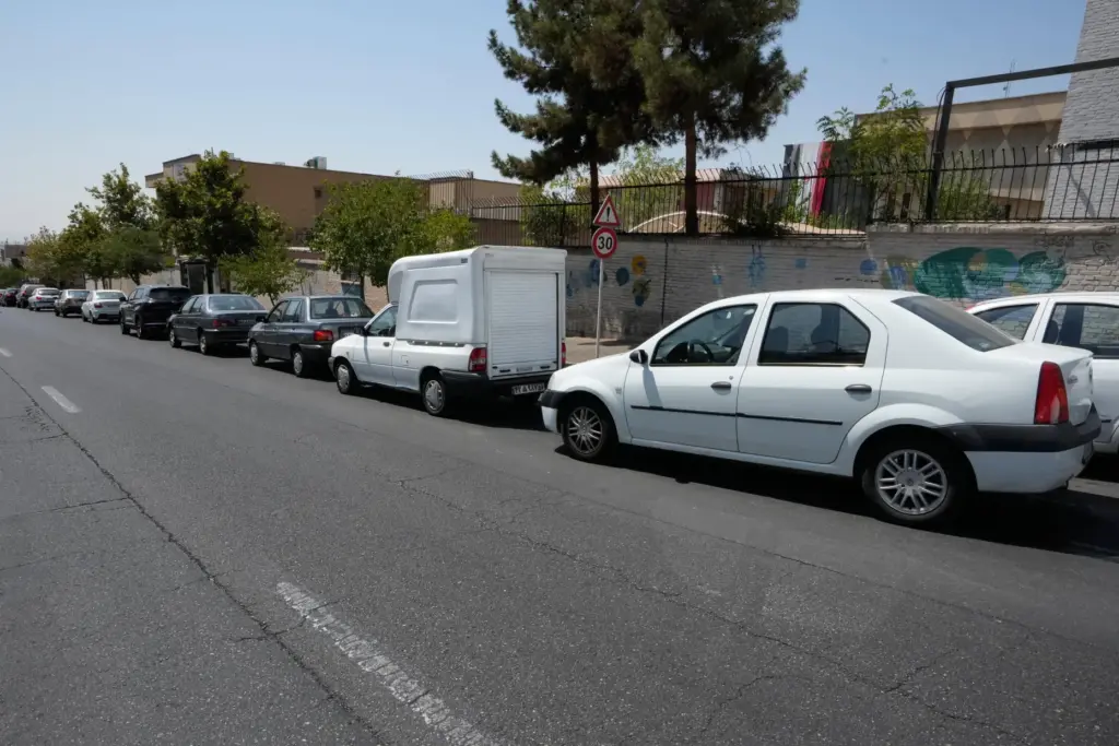 Cars line up outside a gas station in Tehran, Iran,...