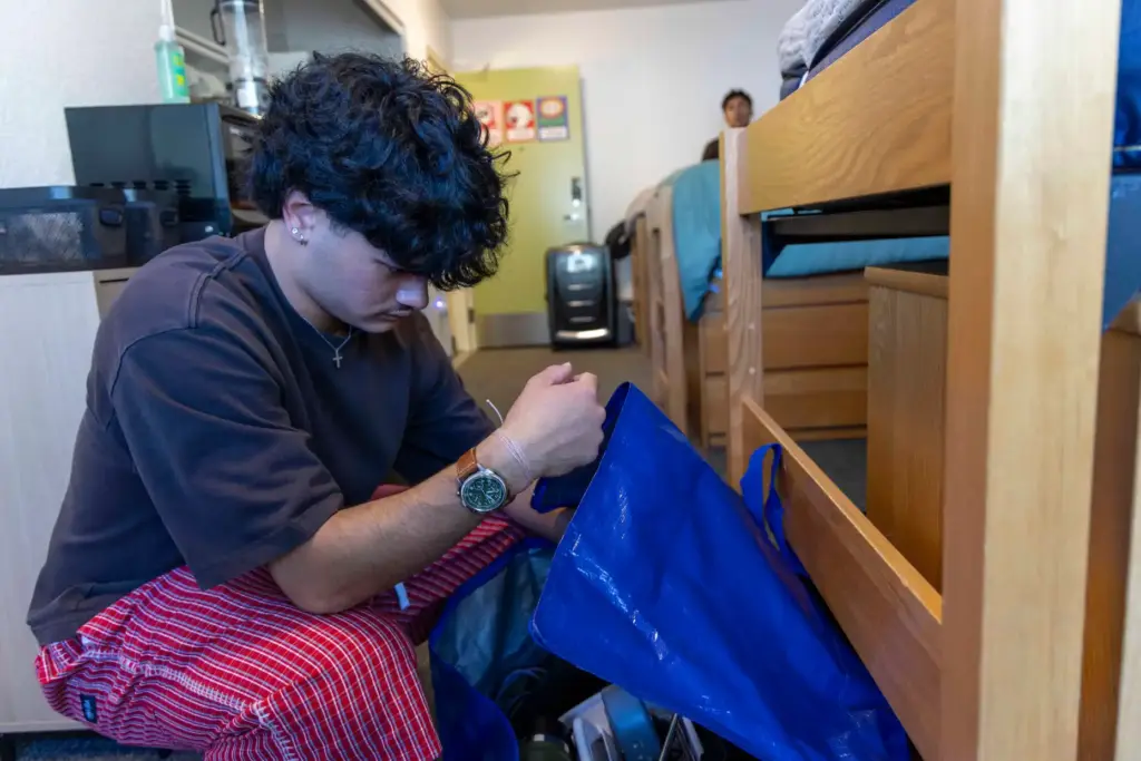 Carsten Schaefer digs through a storage bag for clothes on...