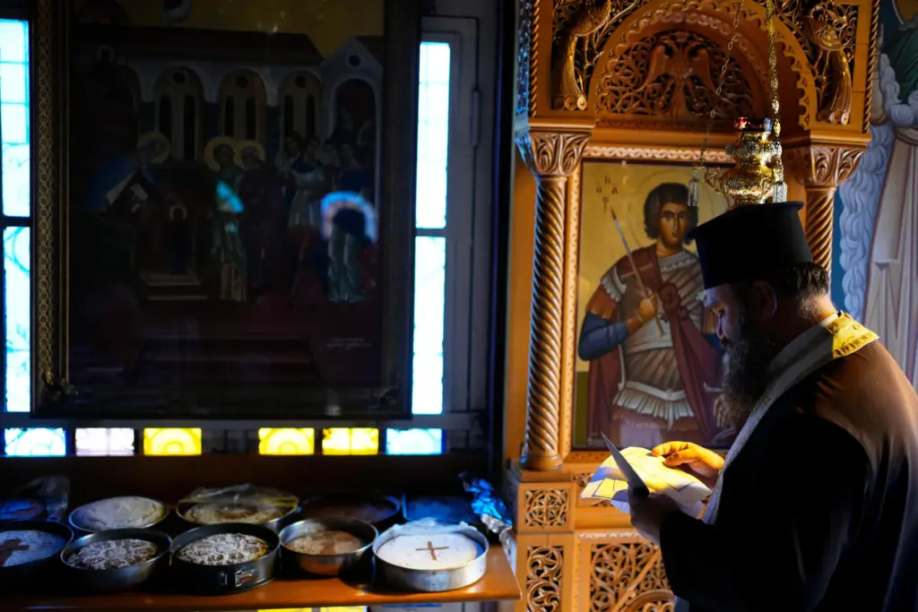 Father Nikolaos Vlavianos blesses the parishioner' Fanouropites.