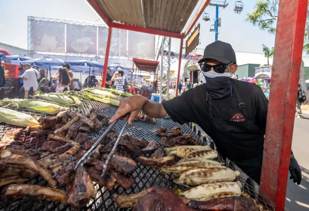 A cook at Backyard Barbecue flips various types of meat...