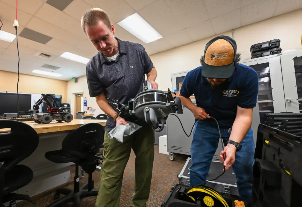 Nicholas Stafford, left, carries a submersible UAV as he and...