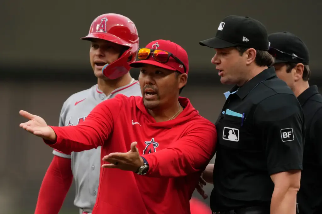 Before being ejected, Angels manager Kurt Suzuki, center, argues with...