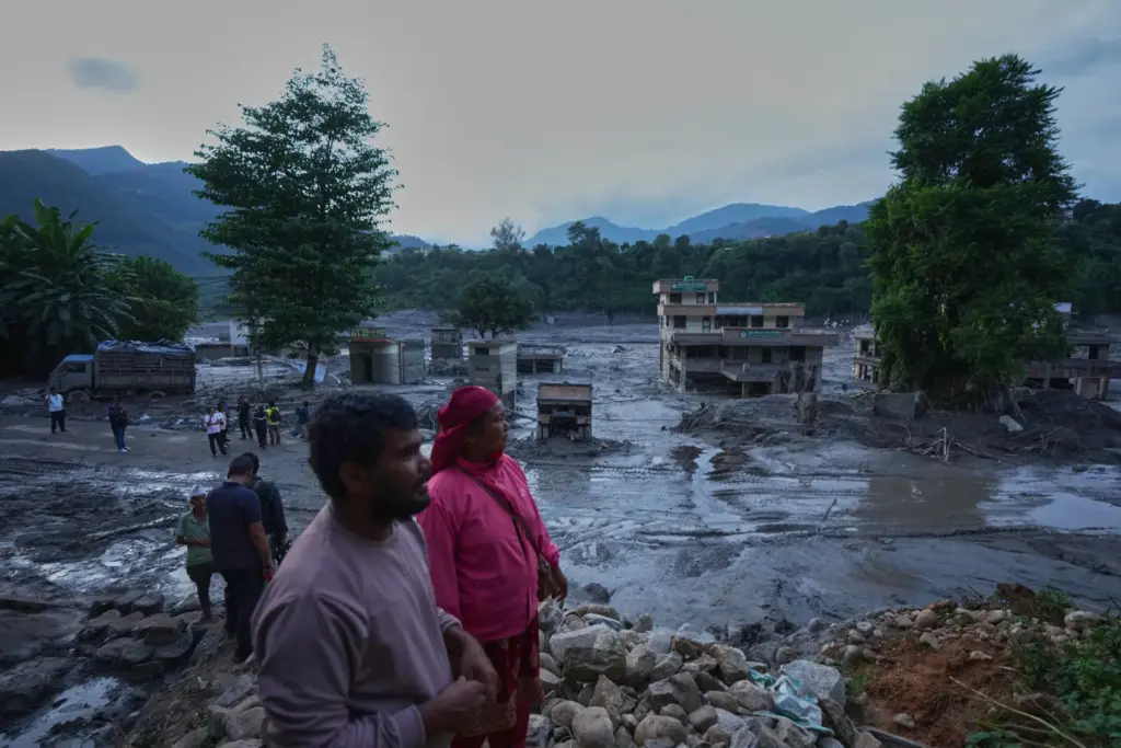 Residents look at the devastation left by flash flooding in...